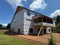 Rear view of under construction home featuring a deck, large windows and a partially finished basement at 2257 Buford Dam Rd, Buford, GA 30518