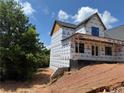 Side view of under construction home showcasing a porch area, windows and wooded lot at 2257 Buford Dam Rd, Buford, GA 30518