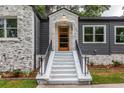 Stylish front entry with modern wooden door and white steps at 1699 Olympian Sw Way, Atlanta, GA 30310