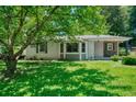 Charming home with a lush green lawn, mature tree, and a welcoming front porch at 3182 Lake Ave, Atlanta, GA 30354