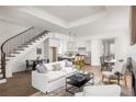 Open-concept living room features a modern staircase, hardwood floors, and a seamless transition to the kitchen at 11566 Serenbe Ln, Chattahoochee Hills, GA 30268