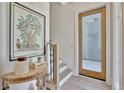 Inviting entryway featuring light wood floors, stairs and decor at 10871 Serenbe Ln, Chattahoochee Hills, GA 30268