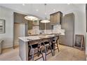 Modern kitchen features stylish gray cabinetry, a marble countertop island with seating at 10871 Serenbe Ln, Chattahoochee Hills, GA 30268