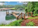 Backyard features a private dock with boat lift on a picturesque lake setting at 6219 Woodlake Dr, Buford, GA 30518