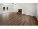 Spacious living room with hardwood floors and a fireplace, bathed in natural light at 225 Woodfield Ct, Mcdonough, GA 30253