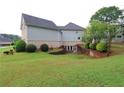 Backyard featuring a large grassy area, mature trees, and a partial view of the home's exterior at 168 Harmony Grove Rd, Lilburn, GA 30047