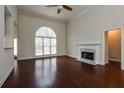Spacious living room featuring hardwood floors, a fireplace, and a large window at 5055 Hickory Hills Dr, Woodstock, GA 30188