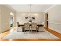 Elegant dining room featuring a chandelier, large window, and hardwood floors at 1655 Arrowhead Ne Trl, Atlanta, GA 30345