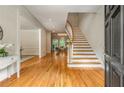 Grand foyer with hardwood floors, curved staircase, and views into the dining room at 1655 Arrowhead Ne Trl, Atlanta, GA 30345