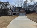 Spacious new home with a brick and stone facade, a three-car garage and a long driveway at 1114 Low Water Crossing, Acworth, GA 30101