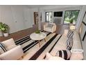 Bright living room with a fireplace and large windows complemented by modern furniture and decor at 3510 Stonewall Se Pl, Atlanta, GA 30339