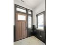 Modern entryway with dark-stained wood door and tiled floor at 11530 Serenbe Ln, Chattahoochee Hills, GA 30268