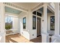 Brick porch with white columns and a light blue ceiling at 11530 Serenbe Ln, Chattahoochee Hills, GA 30268