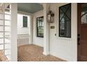 Brick front porch with white columns and a wooden door at 11536 Serenbe Ln, Chattahoochee Hills, GA 30268