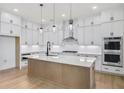 Bright kitchen with stainless steel appliances, white cabinets, large island and stylish pendant lighting at 3025 Sunset Pass, Canton, GA 30114