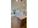 Open kitchen with a large island, modern pendant lighting, and views of the fireplace and living area at 3025 Sunset Pass, Canton, GA 30114
