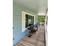 Relax on this covered front porch with wood floors, a small table, and space to enjoy the wooded views at 358 Gold Mine Rd, Dallas, GA 30157