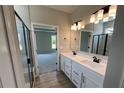 Modern bathroom featuring a double sink vanity with black fixtures, and a glass shower, plus an open doorway at 128 Laurel Farms Ln, Dallas, GA 30157