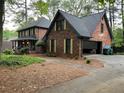Two story brick home with a garage, dark trim, and light-colored shutters at 5741 Wolf Laurel, Lilburn, GA 30047