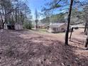Expansive backyard with mature trees, storage shed, and a peek at neighboring houses at 5947 Rock Rd, Union City, GA 30291