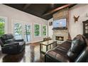 Spacious living room with stone fireplace, wood floors, and lake views from the double doors at 7 Yachting Way, Acworth, GA 30102