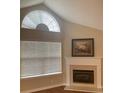 Living room with a vaulted ceiling, large window and a fireplace providing a cozy ambiance at 6133 Malloway Ct, Cumming, GA 30041