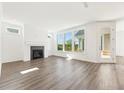 Bright living room with hardwood floors, large windows, and a cozy fireplace at 5235 Maggie Mae Ln, Cumming, GA 30028