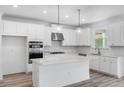 Modern kitchen with white cabinets, quartz countertops, and stainless steel appliances at 5060 Trescott Path, Cumming, GA 30028