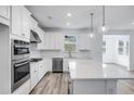Modern kitchen with white cabinets, quartz countertops, and stainless steel appliances at 5060 Trescott Path, Cumming, GA 30028
