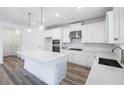 Modern kitchen with white cabinets, quartz countertops, and stainless steel appliances at 5060 Trescott Path, Cumming, GA 30028