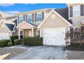 Tan two-story home with white garage doors and landscaping at 4010 Village Run Dr, Mcdonough, GA 30252