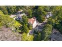 An aerial view shows a home with a brown roof among other houses surrounded by lush trees at 2493 Oldfield Nw Rd, Atlanta, GA 30327