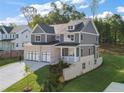 Side view of a new home featuring brick and gray siding, manicured front lawn and three-car garage at 4455 Ryker Rd, Cumming, GA 30041