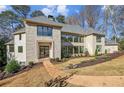 Stunning stone home featuring meticulously manicured landscaping, gray shingles, and modern windows at 825 Kenry Ct, Atlanta, GA 30342