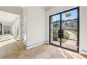 Bright and airy foyer with herringbone floors and grand black framed glass double doors at 825 Kenry Ct, Atlanta, GA 30342