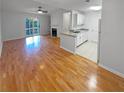 Open-concept living area with hardwood floors connects to kitchen and balcony with natural light at 311 Granville Ct, Atlanta, GA 30328