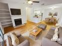 Bright, staged living room with fireplace, ceiling fan, and open floor plan at 311 Granville Ct, Atlanta, GA 30328