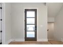 Modern entry door with glass panels and light hardwood floors at 145 Cedarwood Ln, Roswell, GA 30075