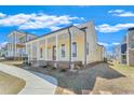 Inviting yellow home showcasing a spacious front porch with stately columns and a neatly maintained landscape at 929 Hilltop Park Ct, Dacula, GA 30019