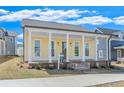 Beautiful yellow home with a covered front porch supported by classic white columns and a well-manicured lawn at 929 Hilltop Park Ct, Dacula, GA 30019