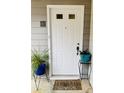 White front door with a welcoming mat and potted plants at 17 Fair Haven Se Way, Smyrna, GA 30080