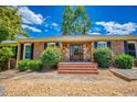 Charming front entrance with brick steps, stone accents, and a double door, surrounded by lush landscaping at 3700 Tom Brewer Rd, Loganville, GA 30052