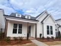 Inviting craftsman-style home with stone columns, dormer windows, and professionally landscaped front yard at 505 Godfrey Dr, Cumming, GA 30040