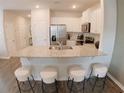 Well-lit kitchen with stainless steel appliances, granite countertops, and island seating at 5895 Mattan Trl, Lithonia, GA 30058