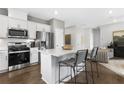 Modern kitchen with stainless steel appliances, white cabinets, and an island with bar seating at 159 Park Ln, Fairburn, GA 30213