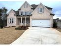 White two-car garage and driveway of a charming brick home at 1077 Sweet Mia Ln, Powder Springs, GA 30127