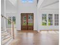 Bright entry with hardwood floors, double doors, and staircase at 5693 Brendlynn Dr, Suwanee, GA 30024