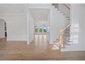 Hardwood floor hallway with staircase and views to living areas at 5693 Brendlynn Dr, Suwanee, GA 30024