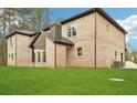 A lush green yard surrounds a brick home with a covered patio at 2861 Tree Top Rd, Dacula, GA 30019