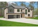 This house features a two-car garage, a gray roof, and a well-maintained lawn at 2861 Tree Top Rd, Dacula, GA 30019